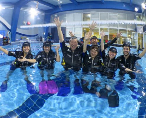 Alunos durante treinamento na piscina do curso de mergulho básico da Captain Dive.
