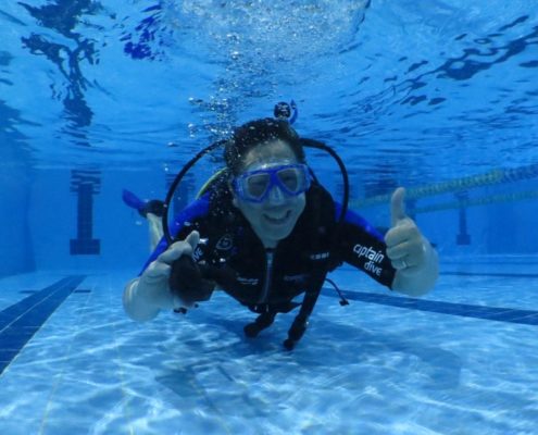 Aluno durante treinamento na piscina do curso de mergulho básico da Captain Dive.