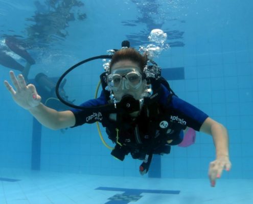 Aluna durante treinamento na piscina do curso de mergulho básico da Captain Dive.